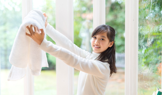 サンルームで洗濯物を干す女性
