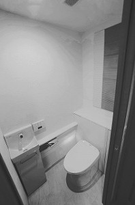 タンクレス、収納一体型、手洗い器付きトイレで空間がスッキリと。背面にはエコカラットも貼りました。